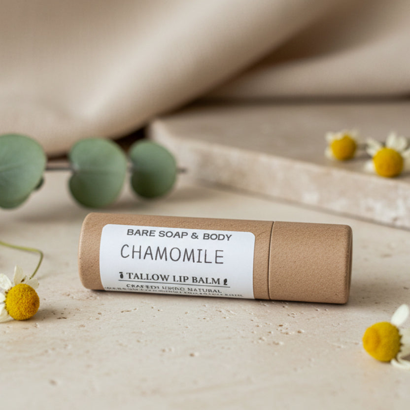 A single tube of Bare Soap & Body Chamomile lip balm resting on a textured gray wood-grain surface.