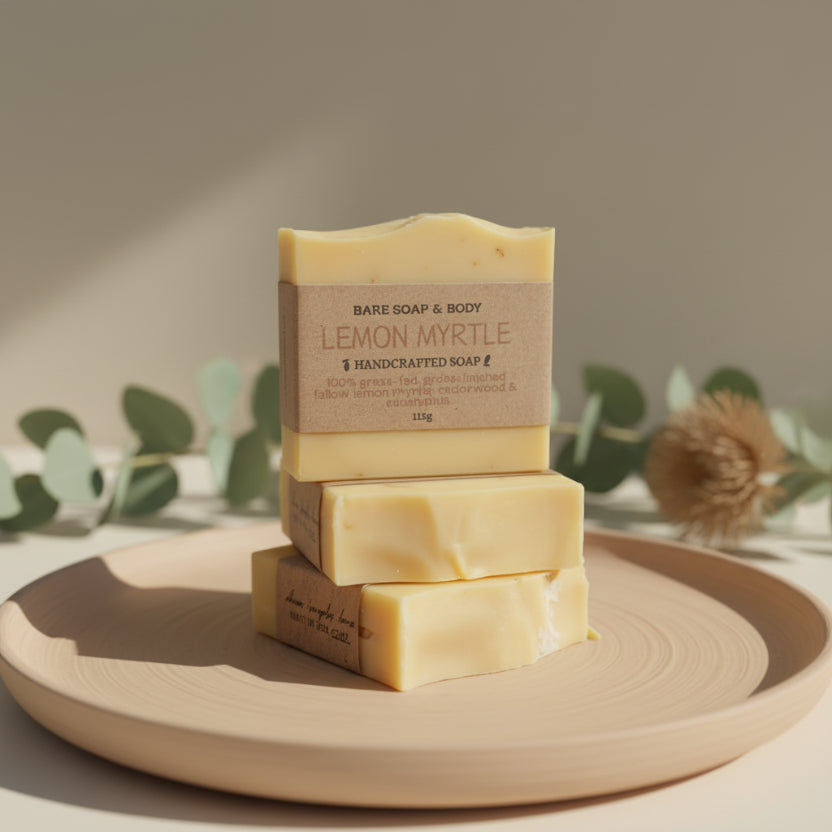Three bars of tallow soap stacked on a tree stump with a natural outdoor background