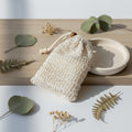 Woven soap bag on a wooden surface