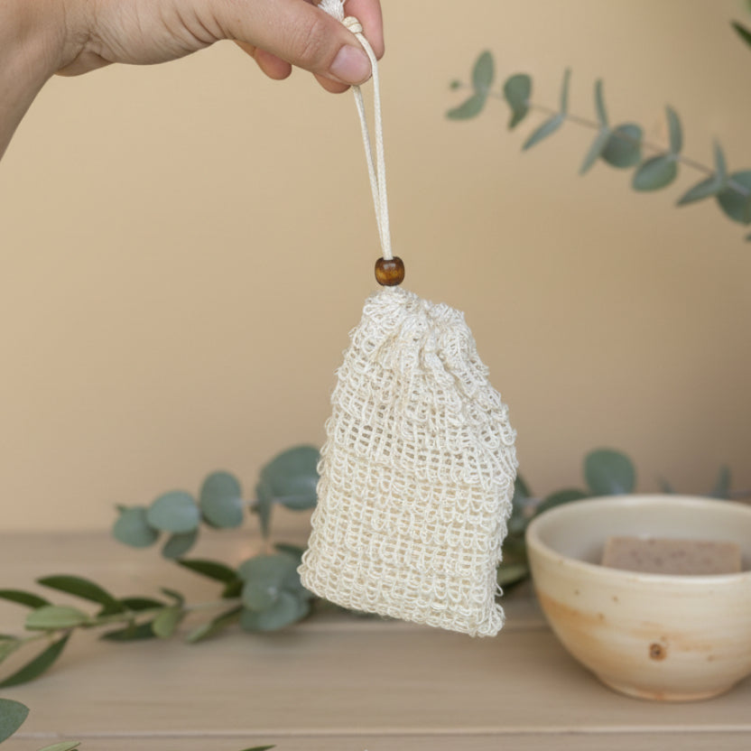 Hand holding a small woven bag with a blurred background