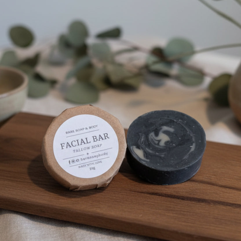 Facial tallow soap bars on a wooden board with a greenery in the background