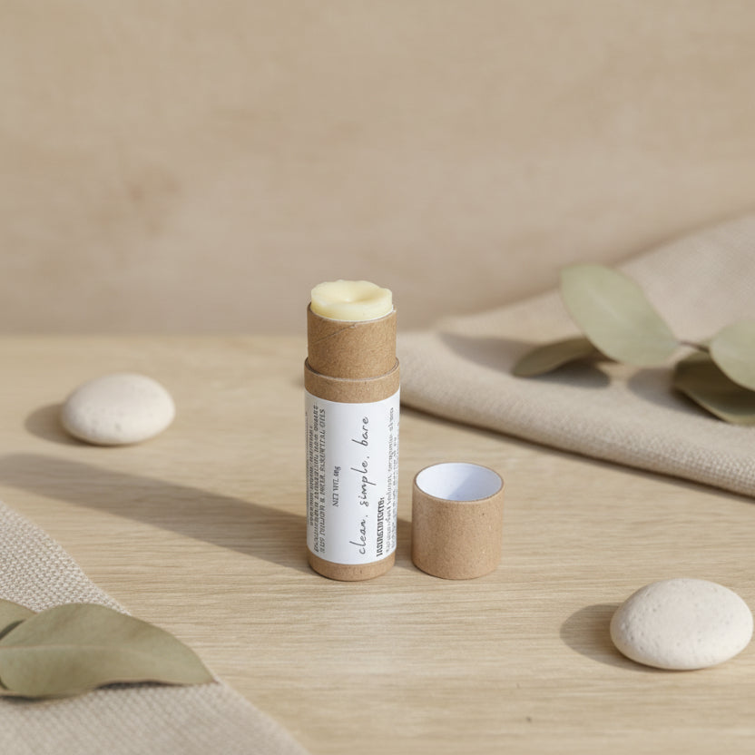 Tallow Lip Balm stick with cardboard tube on a wooden surface