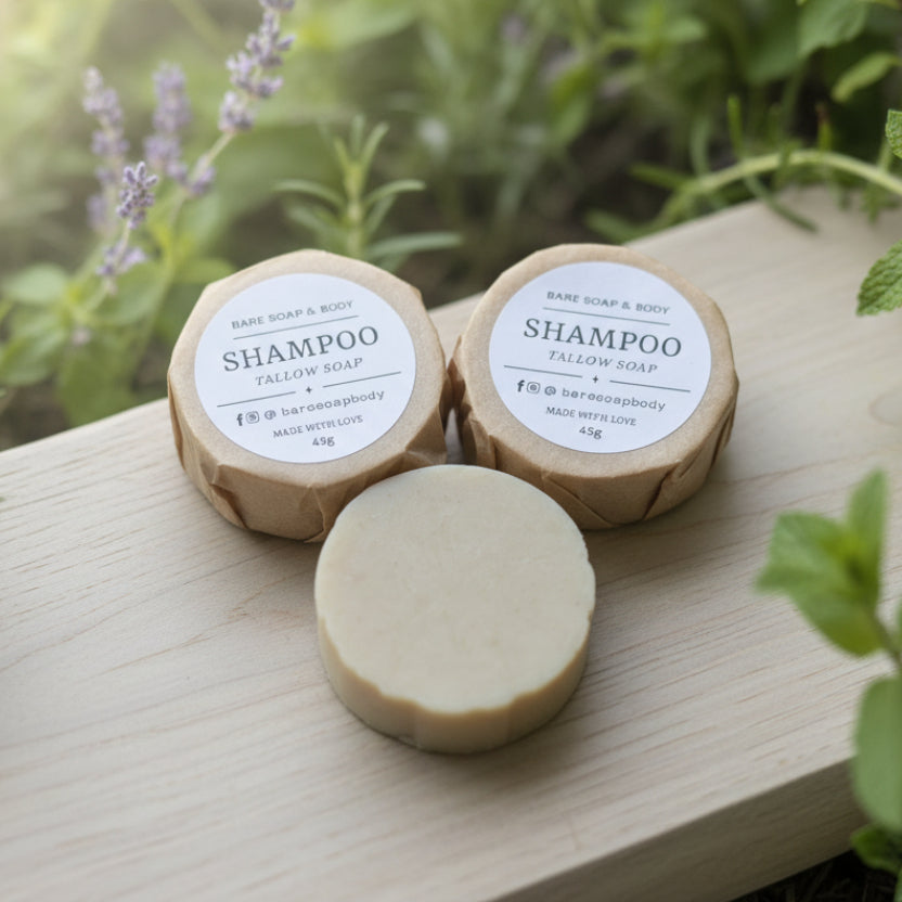 Three tallow shampoo bars on a wooden surface with a herb garden background