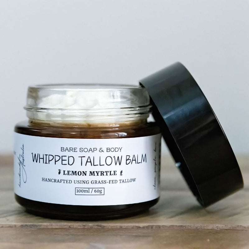 Jar of 'Whipped Tallow Balm' with a black lid on a wooden surface