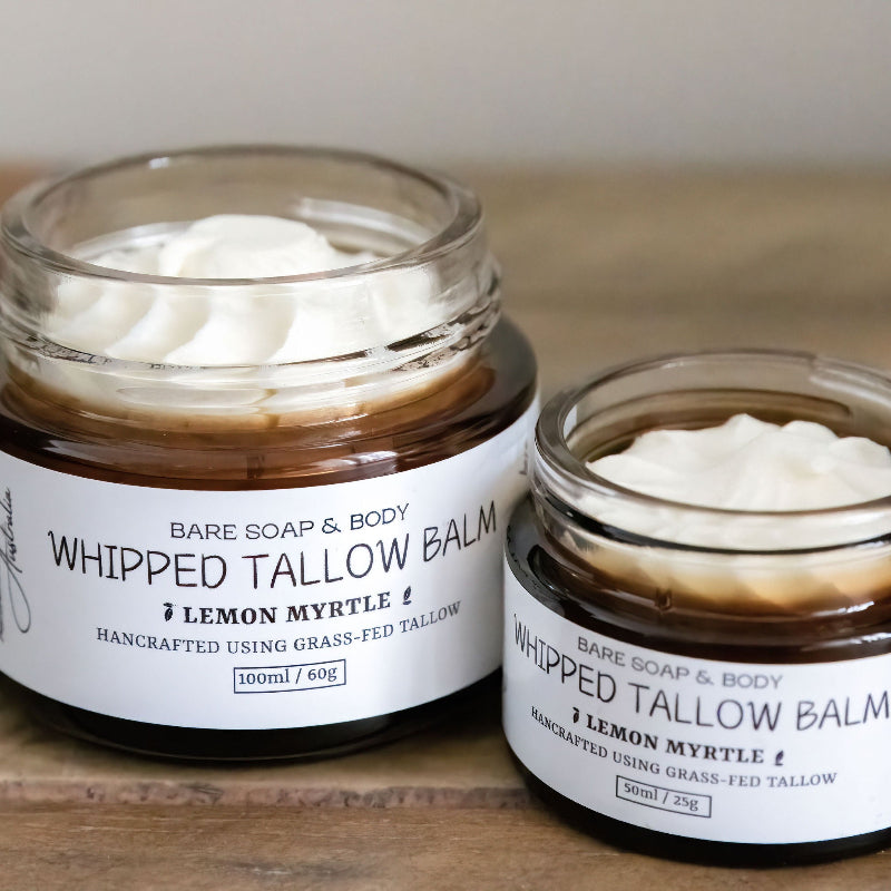 Two jars of 'Whipped Tallow Balm' by Bare Soap & Body on a wooden surface.