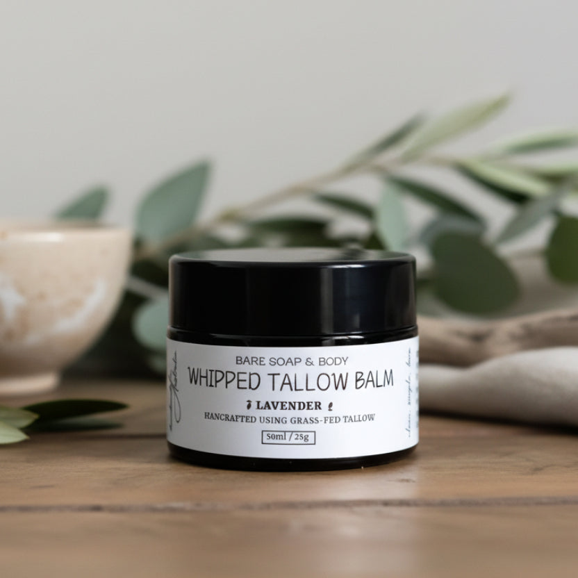 Whipped tallow balm jar labeled 'Bare Soap & Body' on a wooden surface.