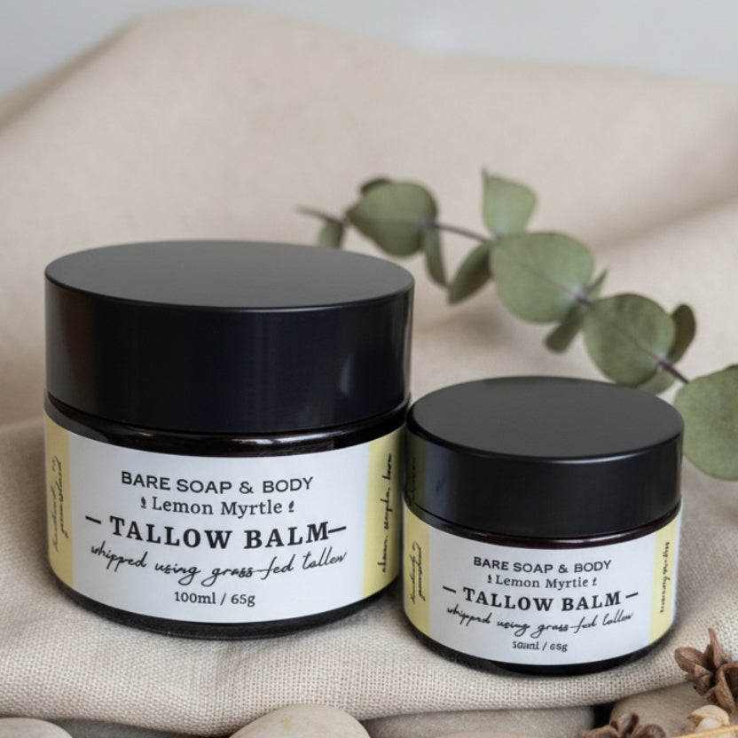Two small jars of Bare Soap & Body Tallow Balm in Lemon Myrtle scent, one 100ml and one 50ml, with black lids and cream labels, placed on a woven brown surface.